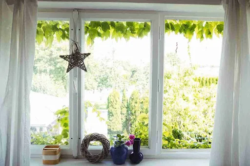 Impact Windows in Pinellas County: What Homeowners Need to Know Modern casement window replacement overlooking the ocean at sunset, highlighting improved insulation and sealing.