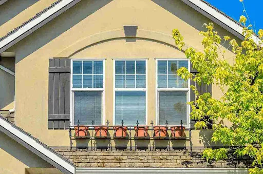 Hurricane Window Ratings Explained for Tampa Bay Homes Modern casement window replacement overlooking the ocean at sunset, highlighting improved insulation and sealing.