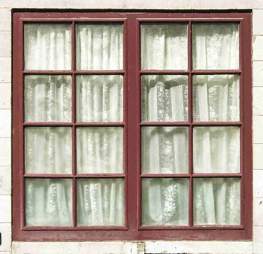 Impact Windows & Florida Insurance: Why Carriers Flag Old Windows Modern casement window replacement overlooking the ocean at sunset, highlighting improved insulation and sealing.